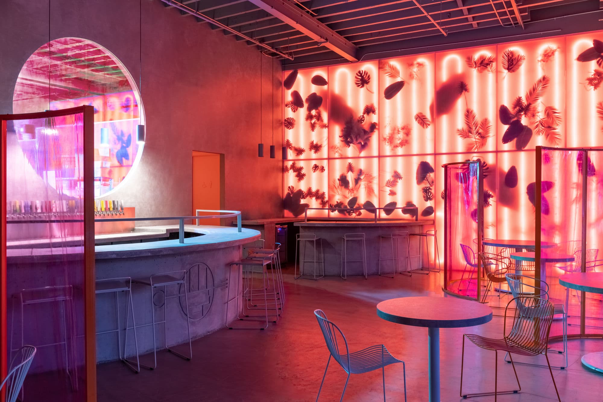 The Wandering Barman Brasserie — neon-lit venue with tropical leaf wall