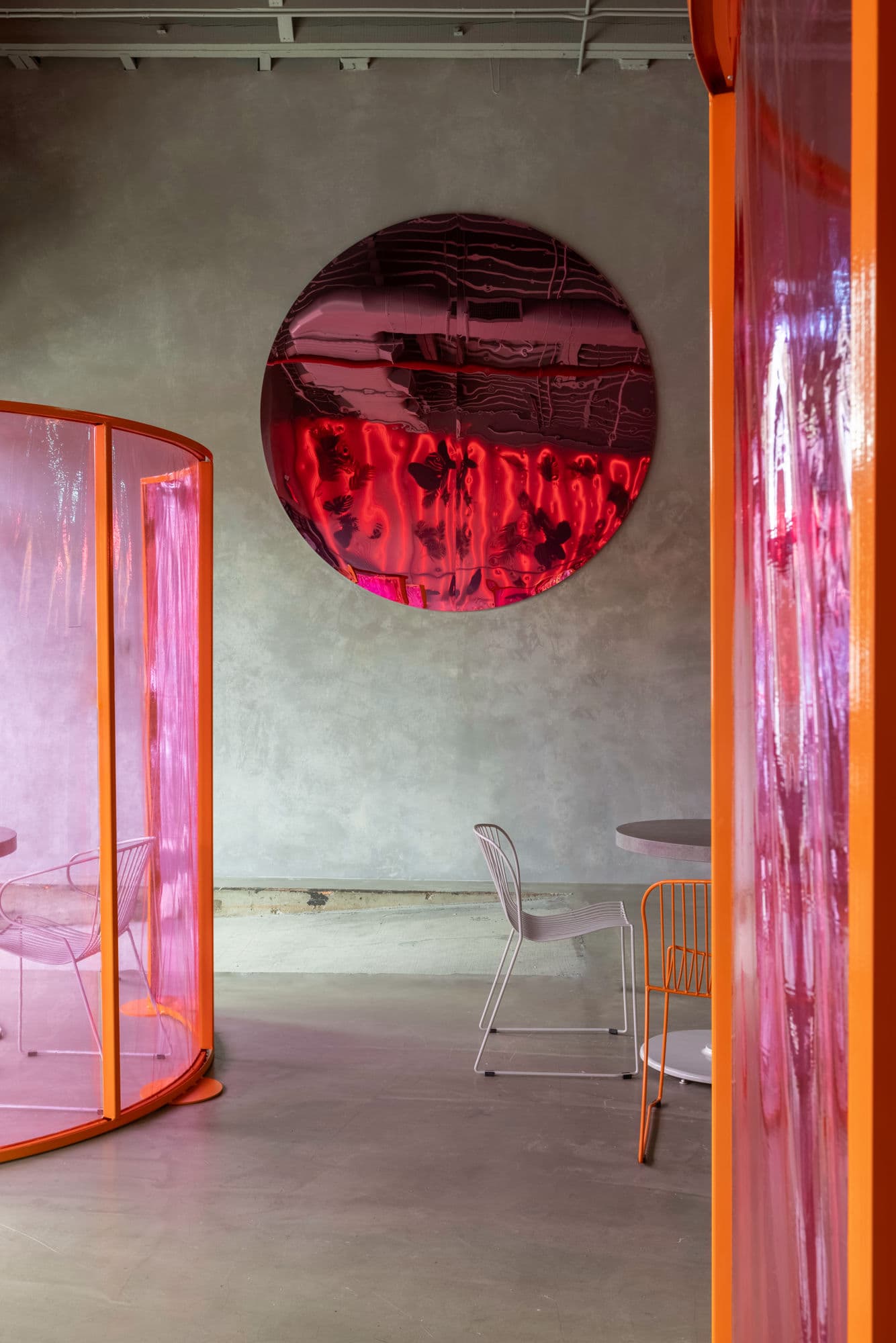 Circular red mirror and orange-framed pink curtain pods